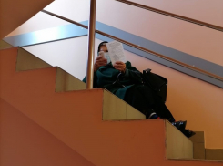 Фото дня: пенсионерка ожидает приема у терапевта на лестнице поликлиники Борисоглебской РБ